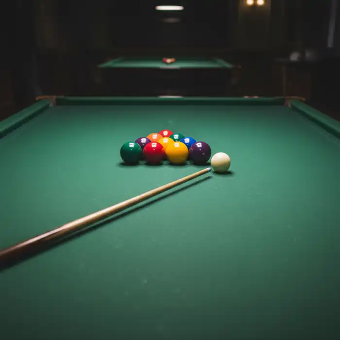 Jak grac w bilarda: Porady dla początkujących graczy – zacząć grać Zbliżenie na stół bilardowy z kolorowymi bilami i kijem, gotowe do gry – jak grac w bilarda.